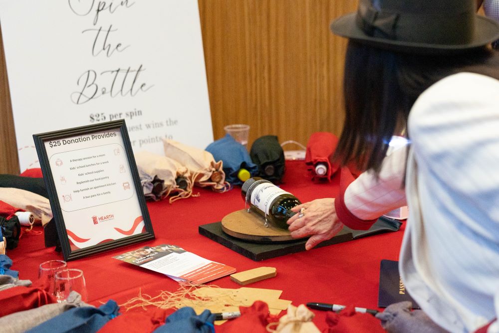 Attendees spin a wine bottle at Hats Off game table
