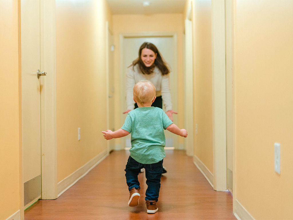 Child running towards mother in a hallway