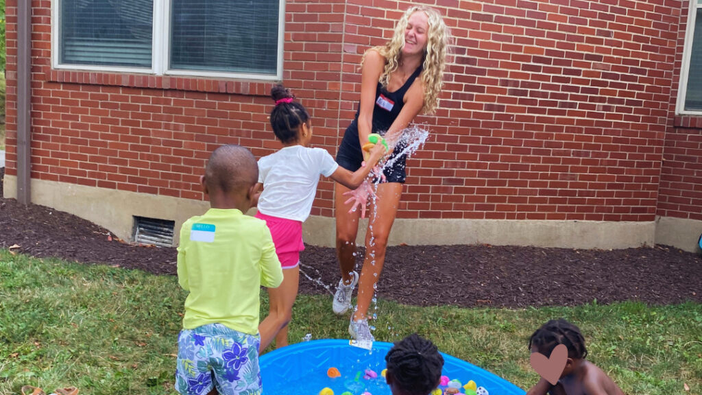 Children playing outside in a baby pool